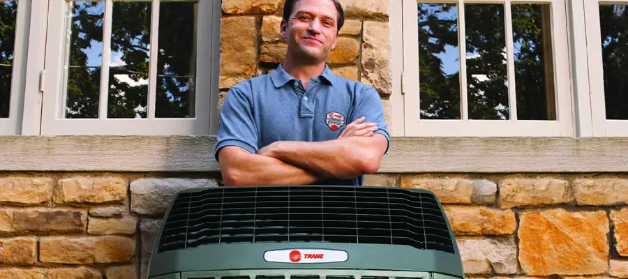 Trane Dealer Standing Behind Heat Pump